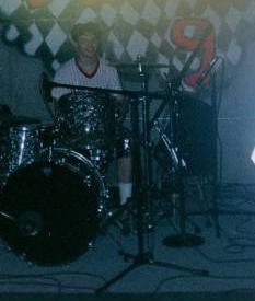 David playing his drums at his band's concert