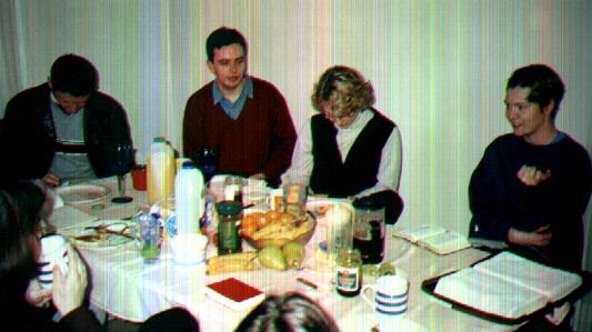 A home group reading the bible over supper