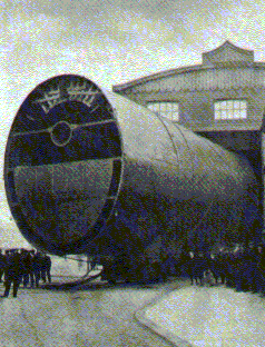 Smoke-stack being hauled out of construction center