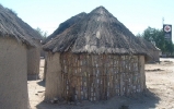 Typical housing (called a rondavel), basically a circular, one-room structure made of mud/hay or other affordable materials... this one has comes with a twist, though:  notice all the aluminum cans used for reinforcement!   CLICK HERE TO SEE A LARGER VERSION OF THIS PHOTO