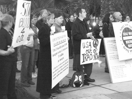 Riverside peace vigil with sign 'USA out of Iraq Now' and 3 others, ~14 people