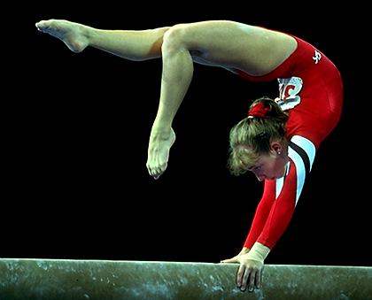 Kim Zmeskal, performing her trademark beam mount: a reverse planche.