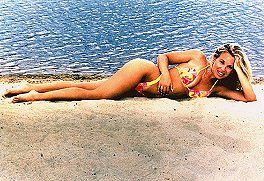 Bikini-clad camille lies on the beach in front of shimmering ocean