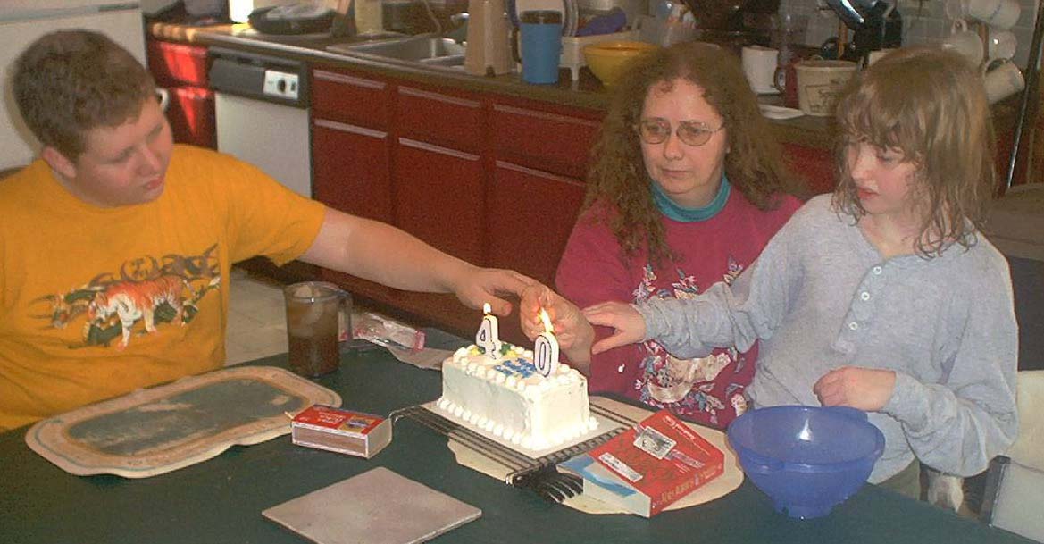 Luke, Cathy, and Kate lighting the big 4-0, February 17, 2001