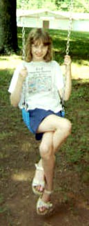 Kate doing her very best Mary Hart imitation on the swing at Easter Seals Camp, June 2001