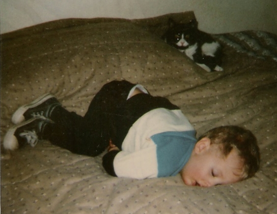 Luke and Mannix in Texas, as Luke continues his car nap on Mom and Dad's bed, March 1989, 2 1/2 years old