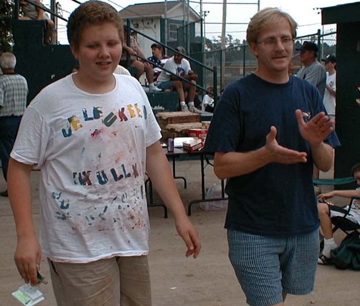 Luke and Jeff walking away with Luke's trophy at the Challenger League pizza party, July 6, 2000