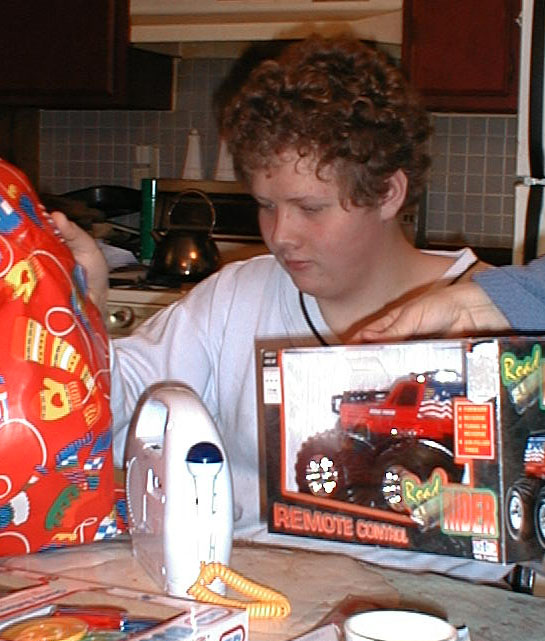 Luke unwrapping presents, December 25, 2001