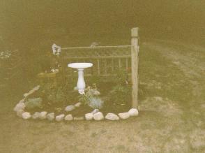 pretty ring of rocks with fencing and birdbath