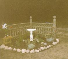  another view of the pretty ring of rocks with fencing and birdbath