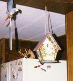 photo of a flowery birdhouse hanging from the ceiling.