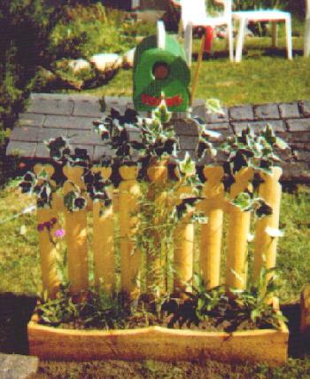 adorable yellow fence planter with mailbox