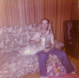 man on couch with baby deer curled up beside him.