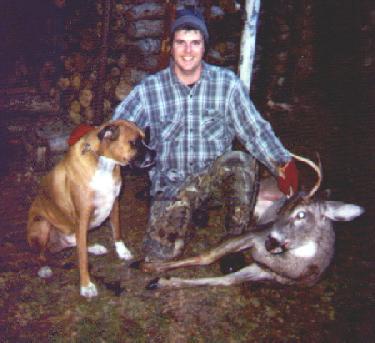 photo of a young man with a deer and a Boxer.