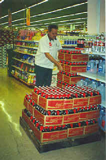 Coke bottles being put on local grocery shelves