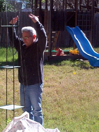 (What are you doing to that plant stand!) - Grandpa does his exercises while Jada plays in the sandbox