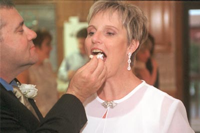 Pat feeds Margaret a bite of cake