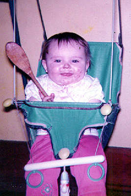 Amanda sitting in her baby swing