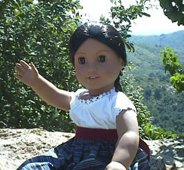 [Josefina in her school dress, sitting on a rock and waving hello.]