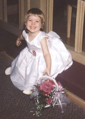 Diana poses in her flower girl dress on Diane's Wedding Day.