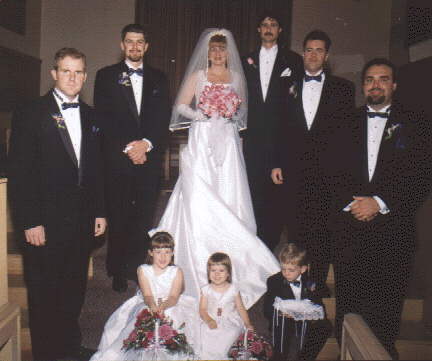 the groomsmen pose with the bride and groom.