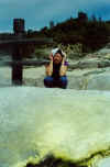 Nicola crouching in front of some sulphur-encrusted rock