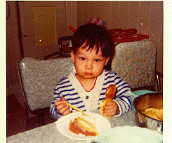 Picture of me at
 two years of age chomping on a drumstick and a piece of cake!