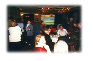 The crowd mingles in the Cloud Room as a video of WOWT reporter standups plays in the background.