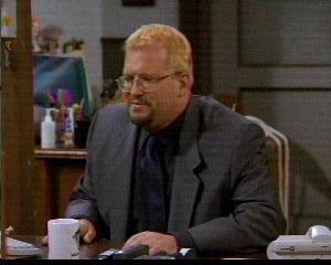 Drew Carey at desk and blonde