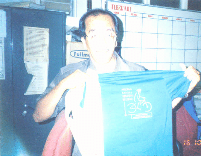 Aminullah Zakariah, special officer of MHI showing a T- Shirt promoting bicycle helmet use.