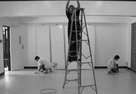 Construction is almost done: a ceiling fan is put in place; while the floor is made dust-free by wiping it with wet rags.