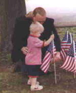 Past Department Commander Kennedy assists a child on Memorial Day.