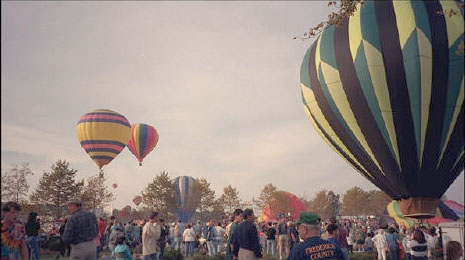 A number of hot air balloons.  Some are air borne.  Some are still setting up for launch.