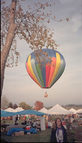 Amanda with hot air balloon airborne behind her.