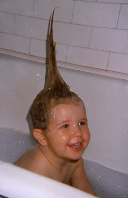 Smiling girl in bath with hair sticking up