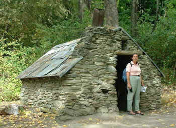 Paula standing in front of a small miners cottage (18950 bytes)