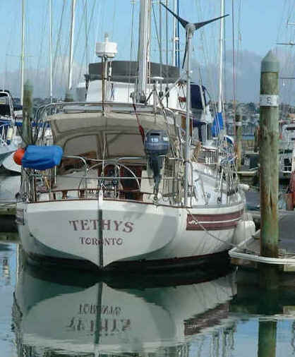 Stern view shows dinghy motor up, instrument arch with radio and GPS antena, radar and wind generator.