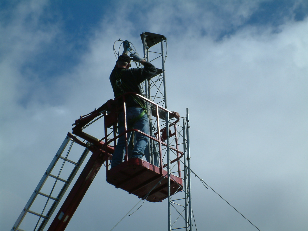 Using a cherry picker to attach the final tower piece