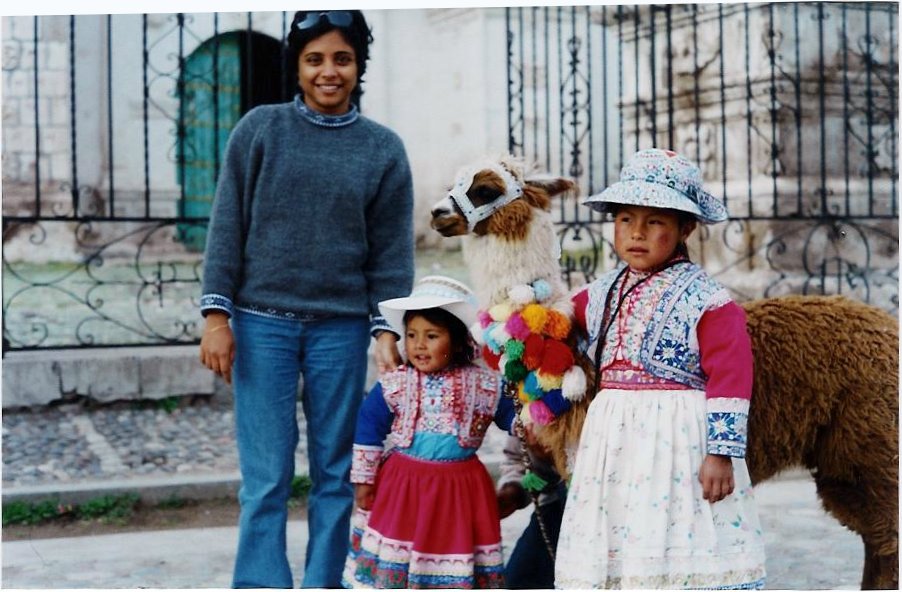 R standing with Inca kids and a llama.