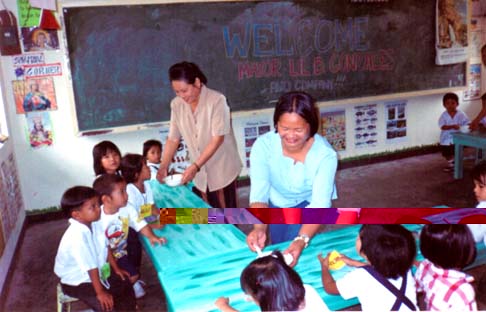 Si Mayor Lil nan OIC-MNAO Rose Portillo sa hinimo na supplemental feeding sa Irosin Central School.