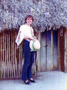 Image of Elizabeth Anne VanderPutten in front of a thatched roof Mexican building