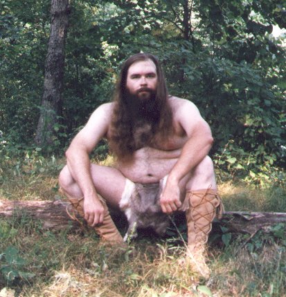 Rabbit skin loincloth, outdoors seated on log