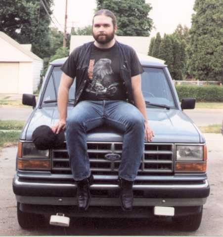 Songdog with shirt and vest, on truck