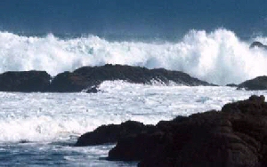 Photo of waves crashing against rocks