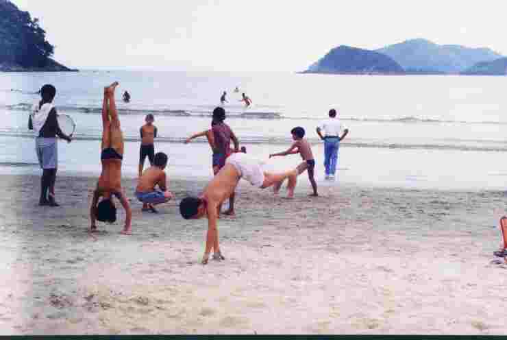 Meninos jogam capoeira.