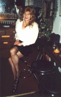 Short black skirt, white ruffled blouse and black hold-up stockings