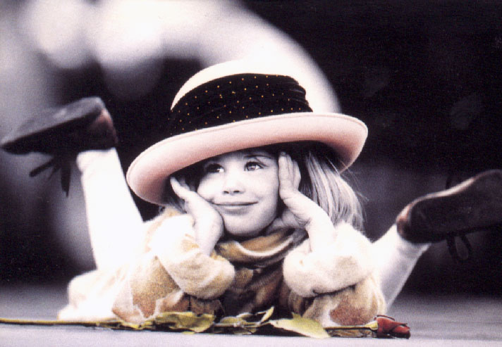 Smiling girl with rose and hat